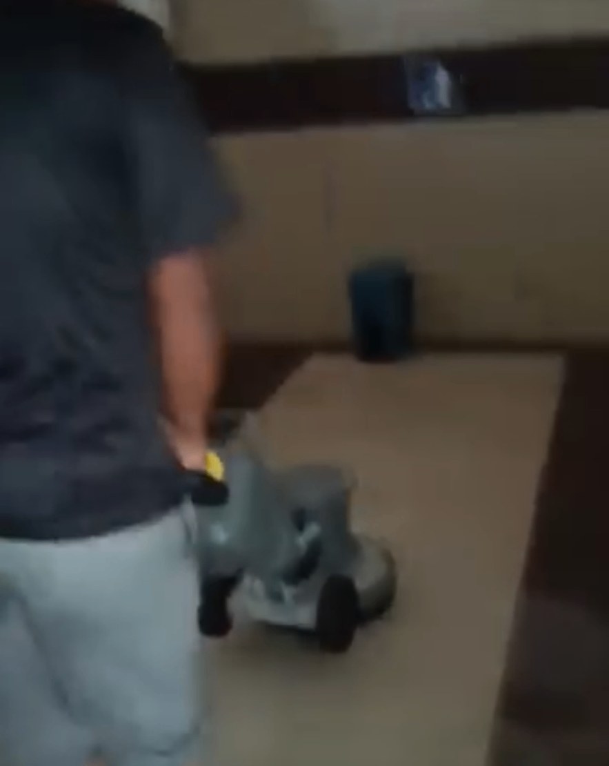 Kerja sental lantai menggunakan mesin di ruang pejabat.